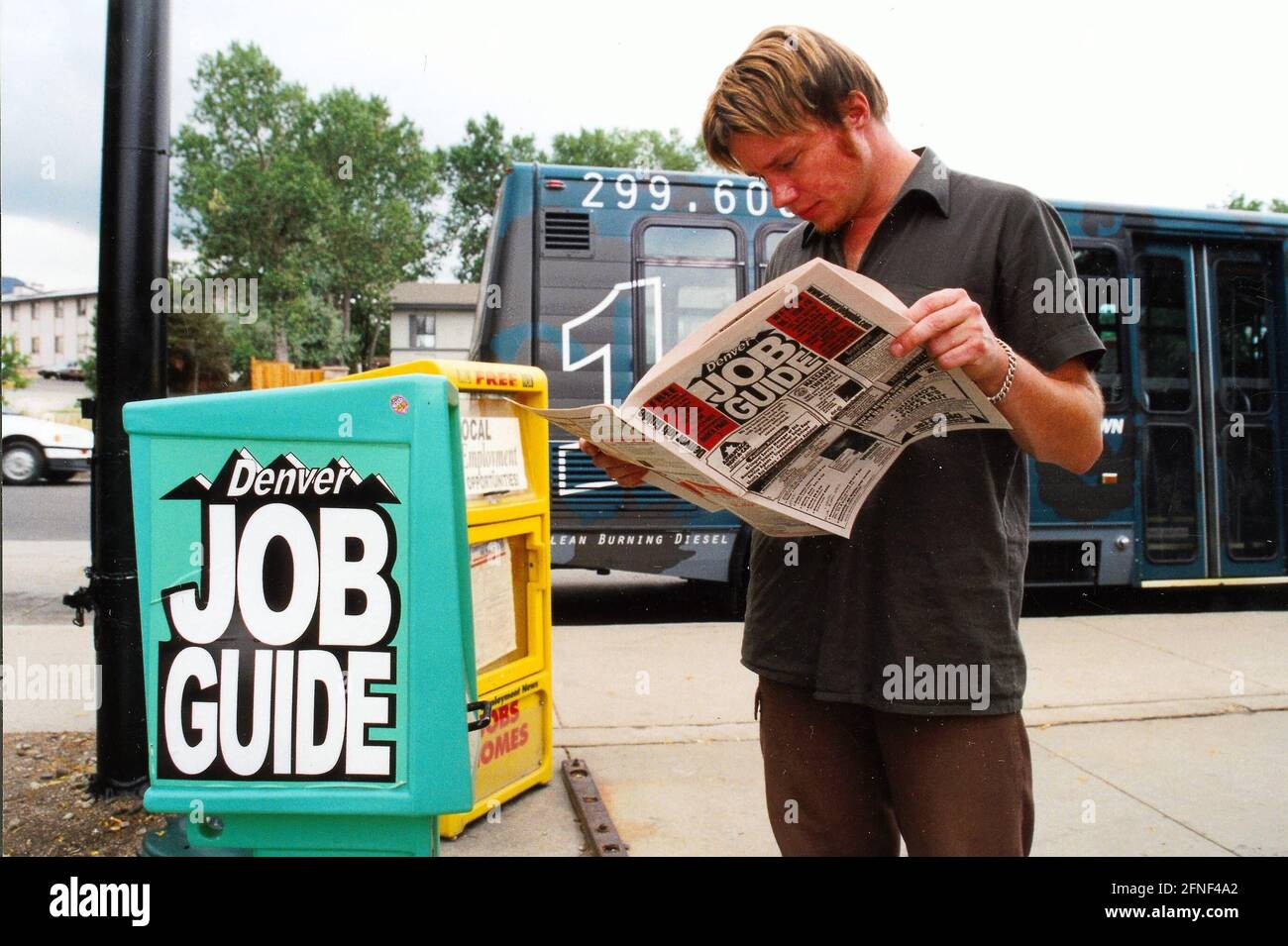 Job hunting in America: teenager reads job ads in 'Denver Job Guide' newspaper. [automated translation] Stock Photo