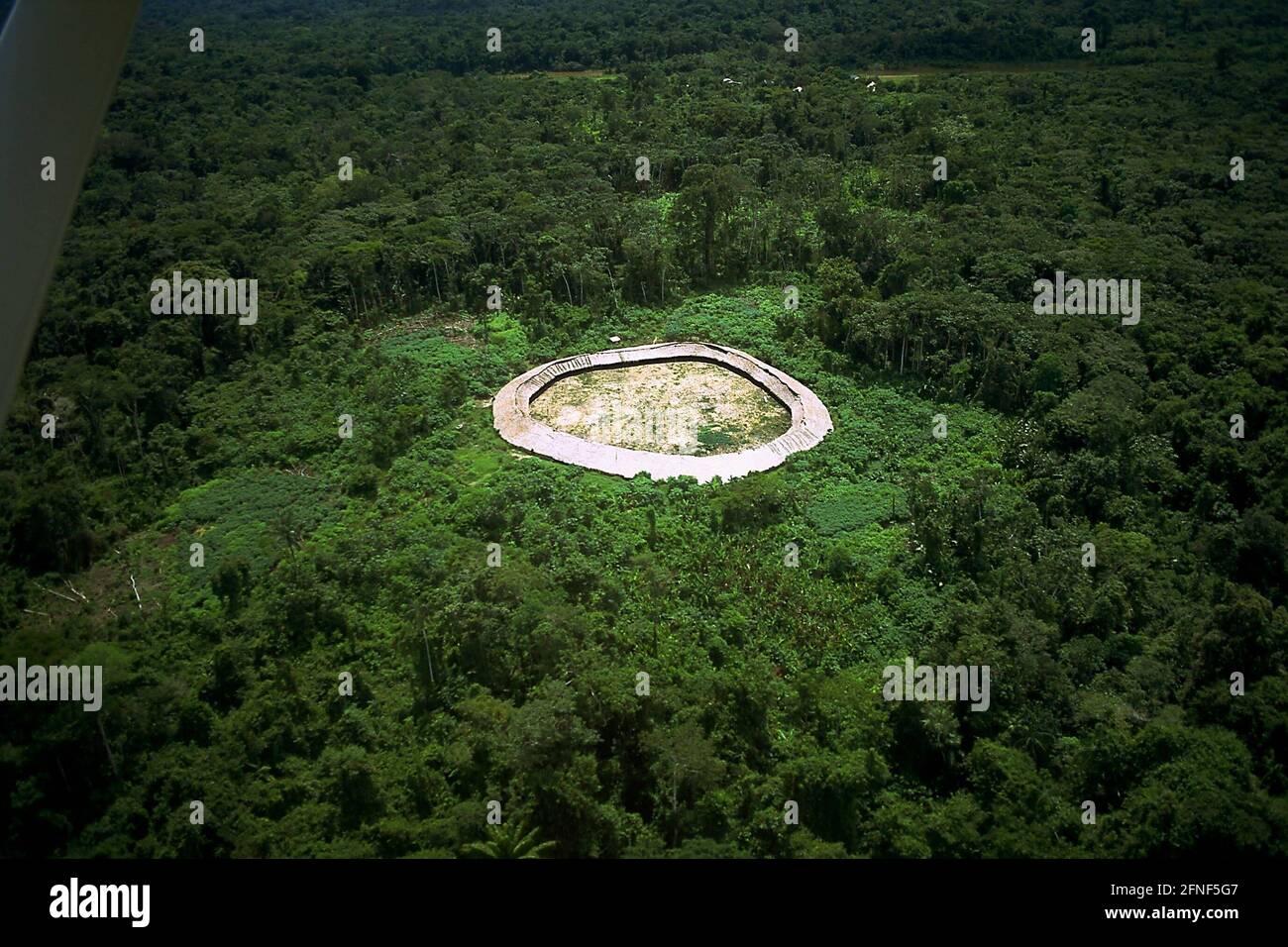 A Yanomami settlement in the middle of the tropical rainforest. The Yanomami live in small, widely scattered villages in the forest, rather than along riverbanks like most other tribes. They form extended families of 30-100 members, each sharing a maloca - a long, large round house. The term Shapono or Shabono is also commonly used for this round house. [automated translation] Stock Photo