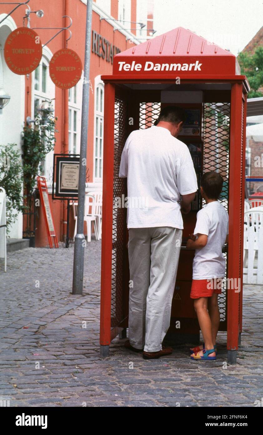 Father and son talking on the phone in a Tele Danmark phone booth in Copenhagen.n [automated translation] Stock Photo