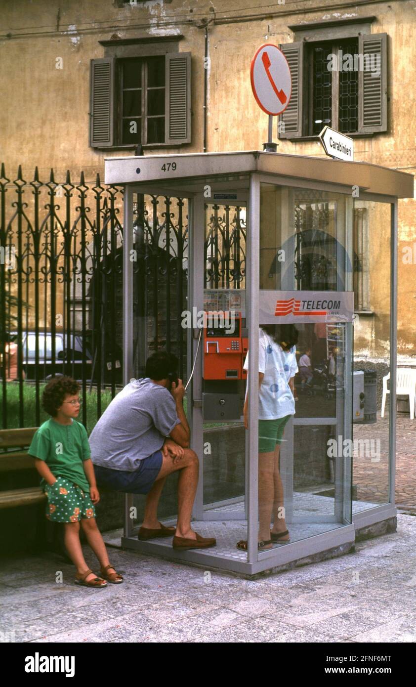 A mother and her children talk on the phone in a Telecom Italia phone booth in Tirano.n [automated translation] Stock Photo
