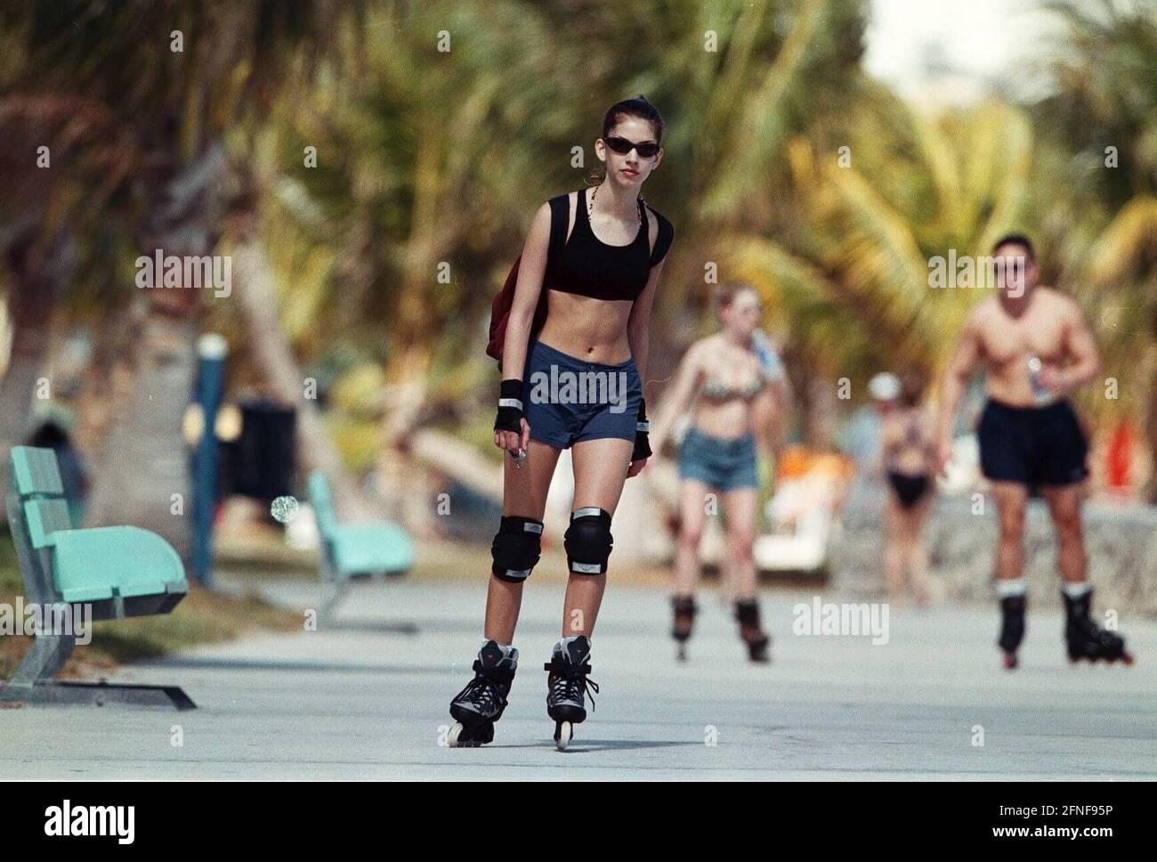 Date of recording: 14.02.1999 Roller-blader riding on the boardwalk under palm trees in Miami Beach, America. [automated translation] Stock Photo