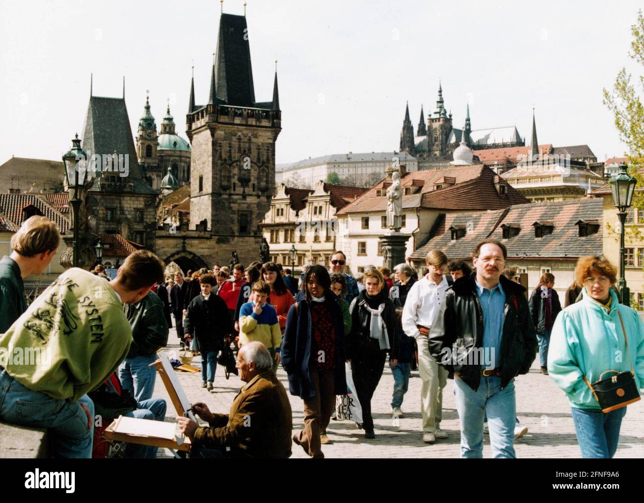 The connection between the Old Town and the Lesser Town in Prague is the Charles Bridge, today a meeting point for tourists. In the background the two bridge towers of the Lesser Town, in between the Church of St. Nicholas and right above the Hrad?any, the Prague Castle. [automated translation] Stock Photo