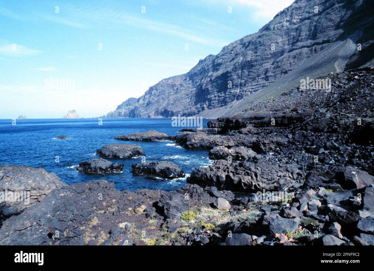 EL HIERO - CANARY ISLANDS Bare black ash mountains, lava rocks in the blue sea. [automated translation] Stock Photo