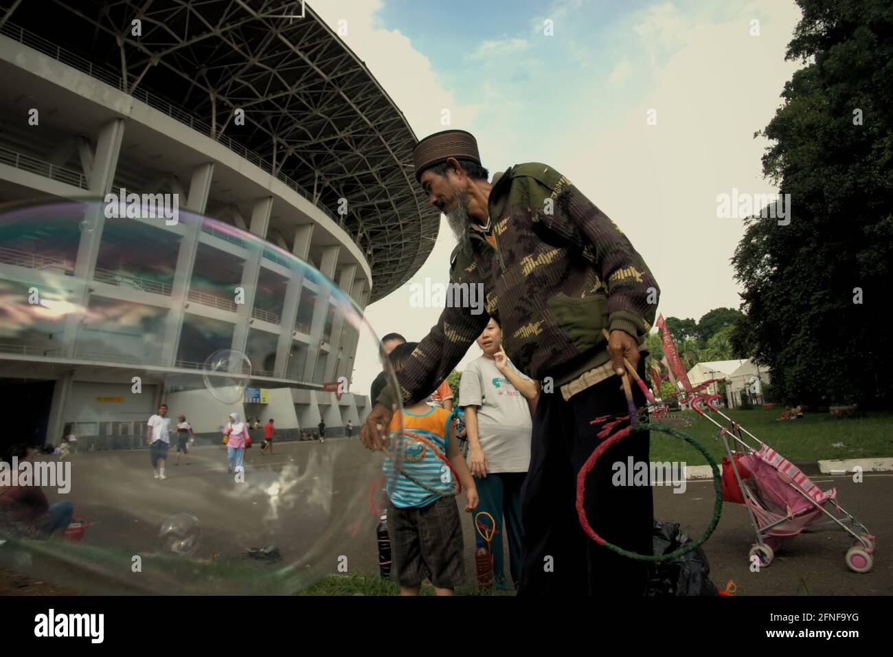 A Soap Bubble Itinerant Helping A Child With His New Plaything Outside Main Stadium In Senayan Sports Complex Gelora Bung Karno In Jakarta Indonesia Stock Photo Alamy