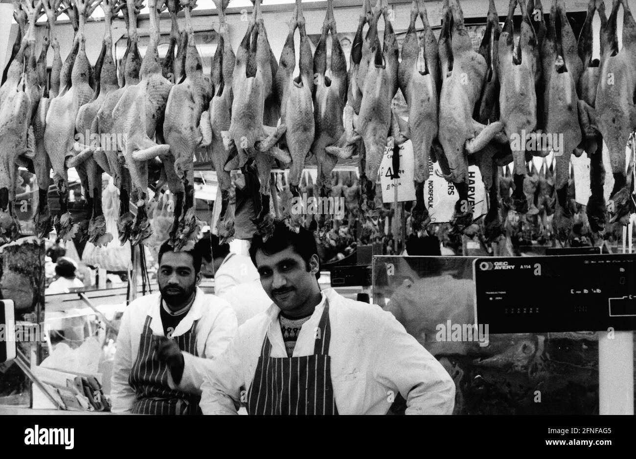 Arab vendors behind a meat counter in the Brixton market district of