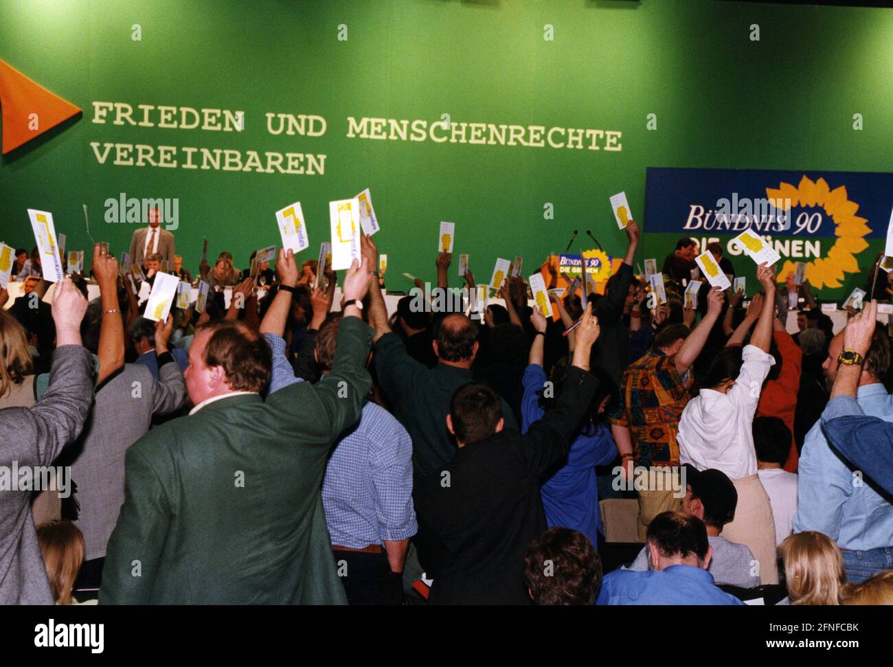 Delegates at the federal party conference of the Alliance 90/The Greens  party vote on the deployment of German military forces in the Kosovo war.  In the background the slogan: 