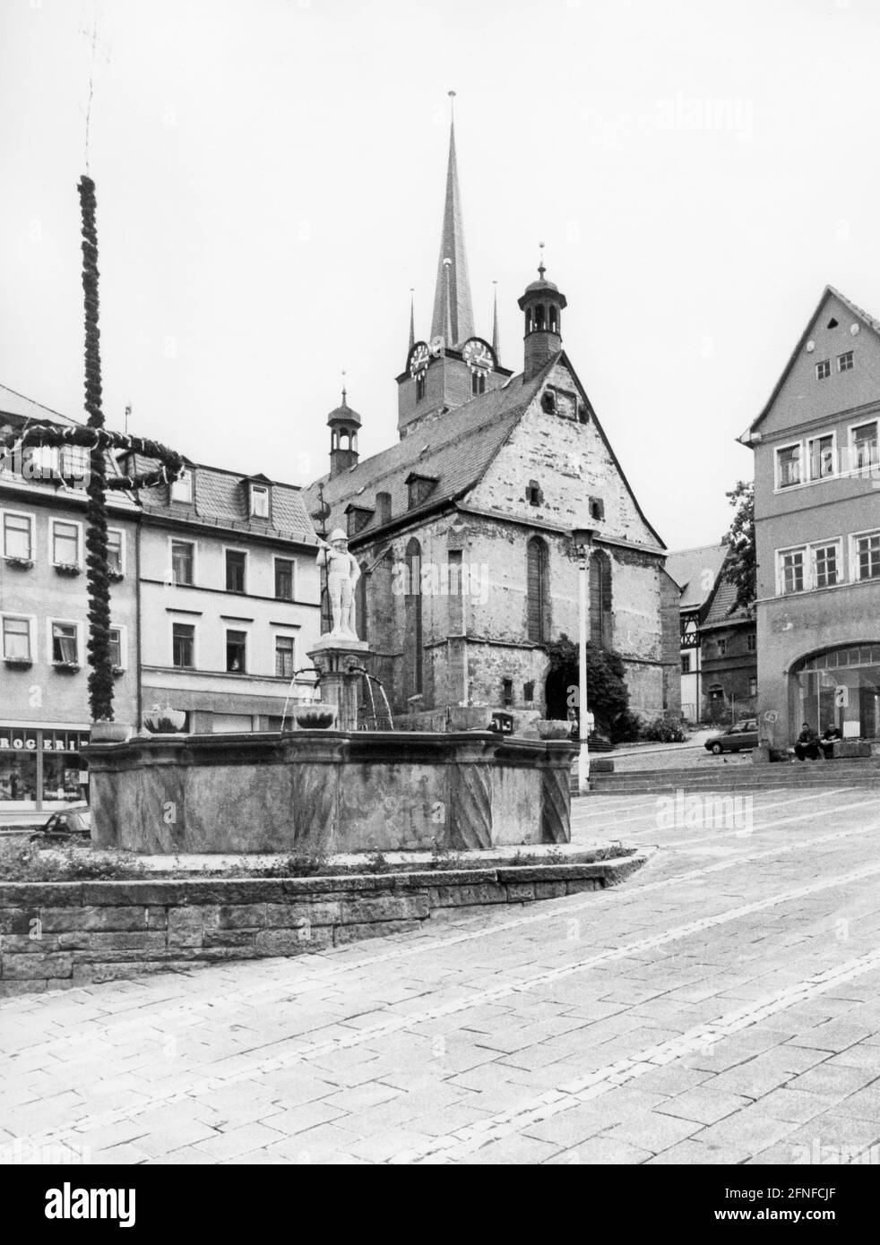Panoramic view onto the market square in Pößneck, Thuringia, with a fountain and a market bear, behind it the Gothic town church St. Bartholomew, which was finished in the 15th century. [automated translation] Stock Photo