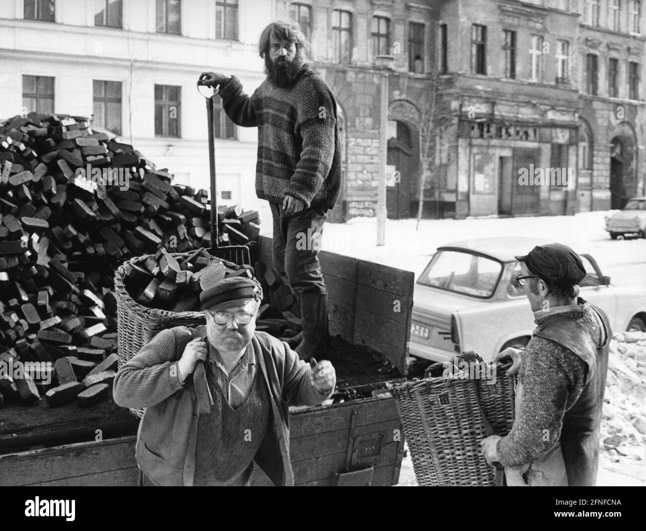 Three men deliver coal to private households in East Berlin shortly after reunification. The background to the photograph was the limited quantities per household and the resulting conflicts. [automated translation] Stock Photo