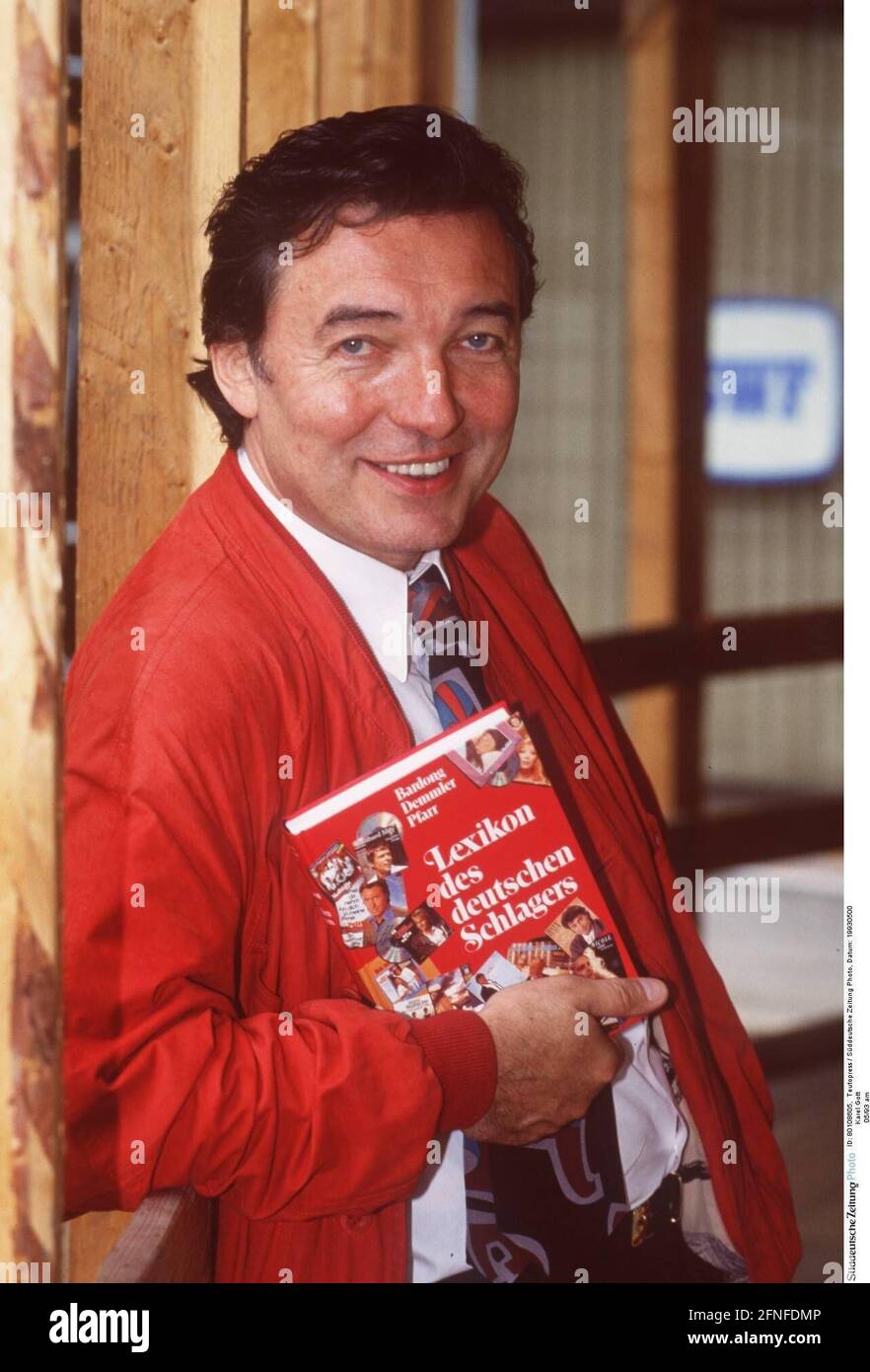 Karel Gott 05/93 at man singing hit dark-haired serious high half book hands jacket red smiling [automated translation] Stock Photo