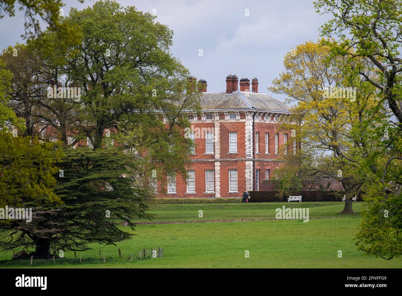 Beyond grazing parkland and a protective ha-ha, the elegant southern façade of Beningbrough Hall, North Yorkshire, UK Stock Photo