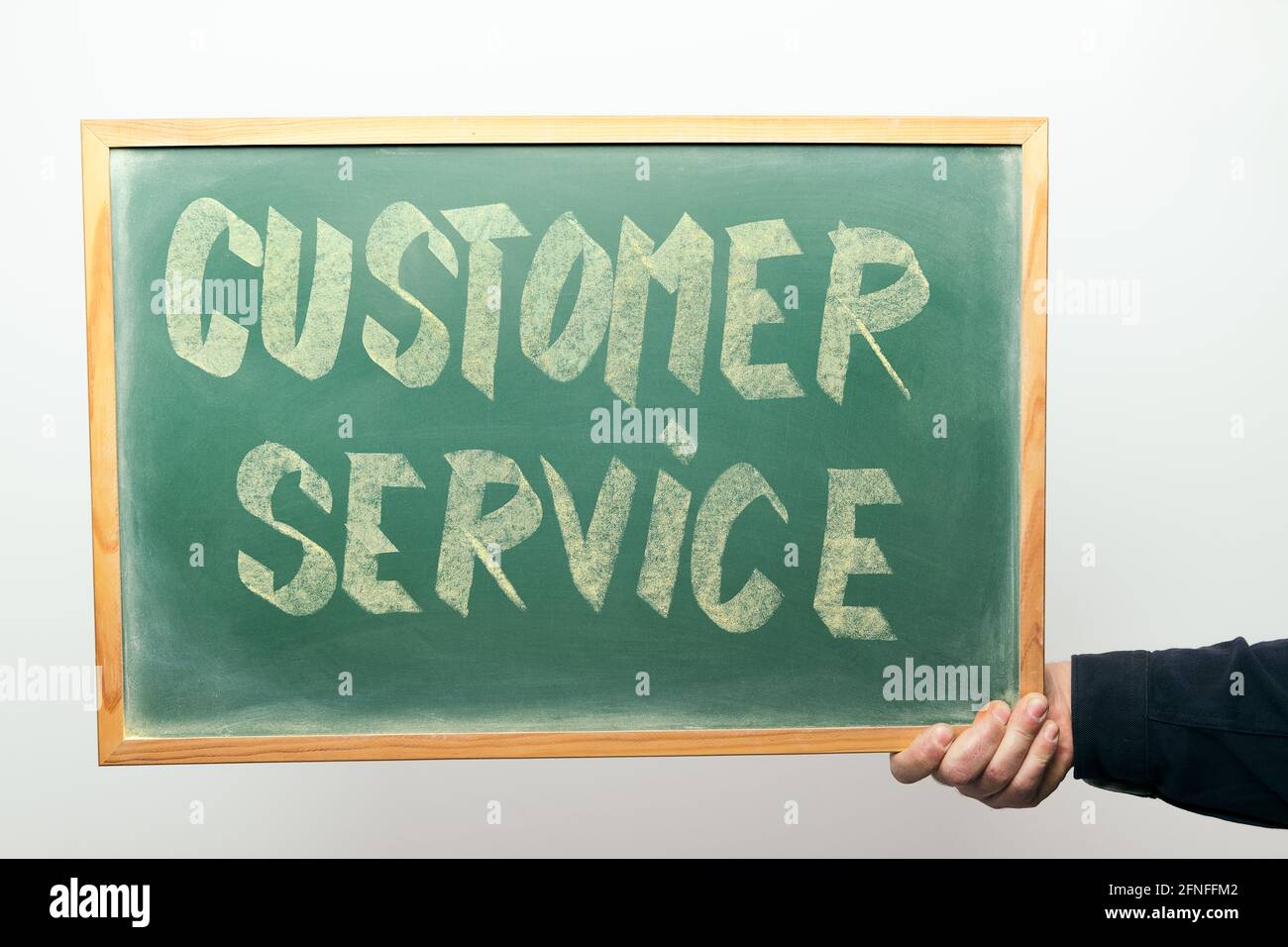 hand holding a chalkboard with the message CUSTOMER SERVICE handwritten ...