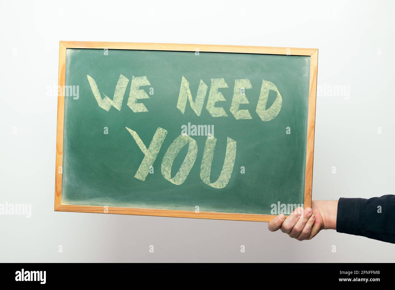 hand holding a chalkboard with the message WE NEED YOU handwritten in ...