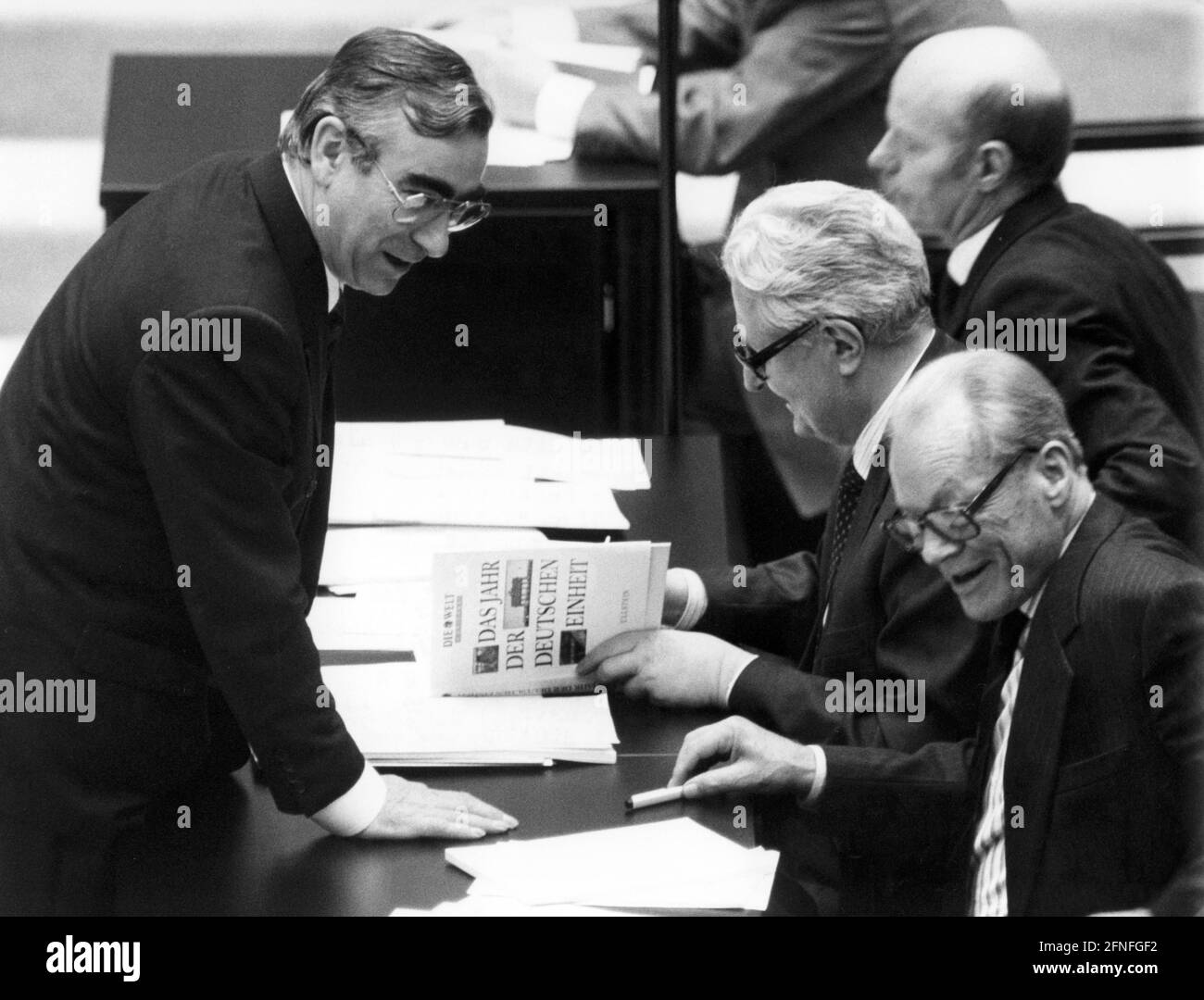 'The Federal Minister of Finance and CSU Chairman Theodor Waigel (l.) has the book ''Das Jahr der deutschen Einheit'' (The Year of German Unity) signed by Hans-Jochen Vogel (centre right) during a break in the Bundestag session. [automated translation]' Stock Photo