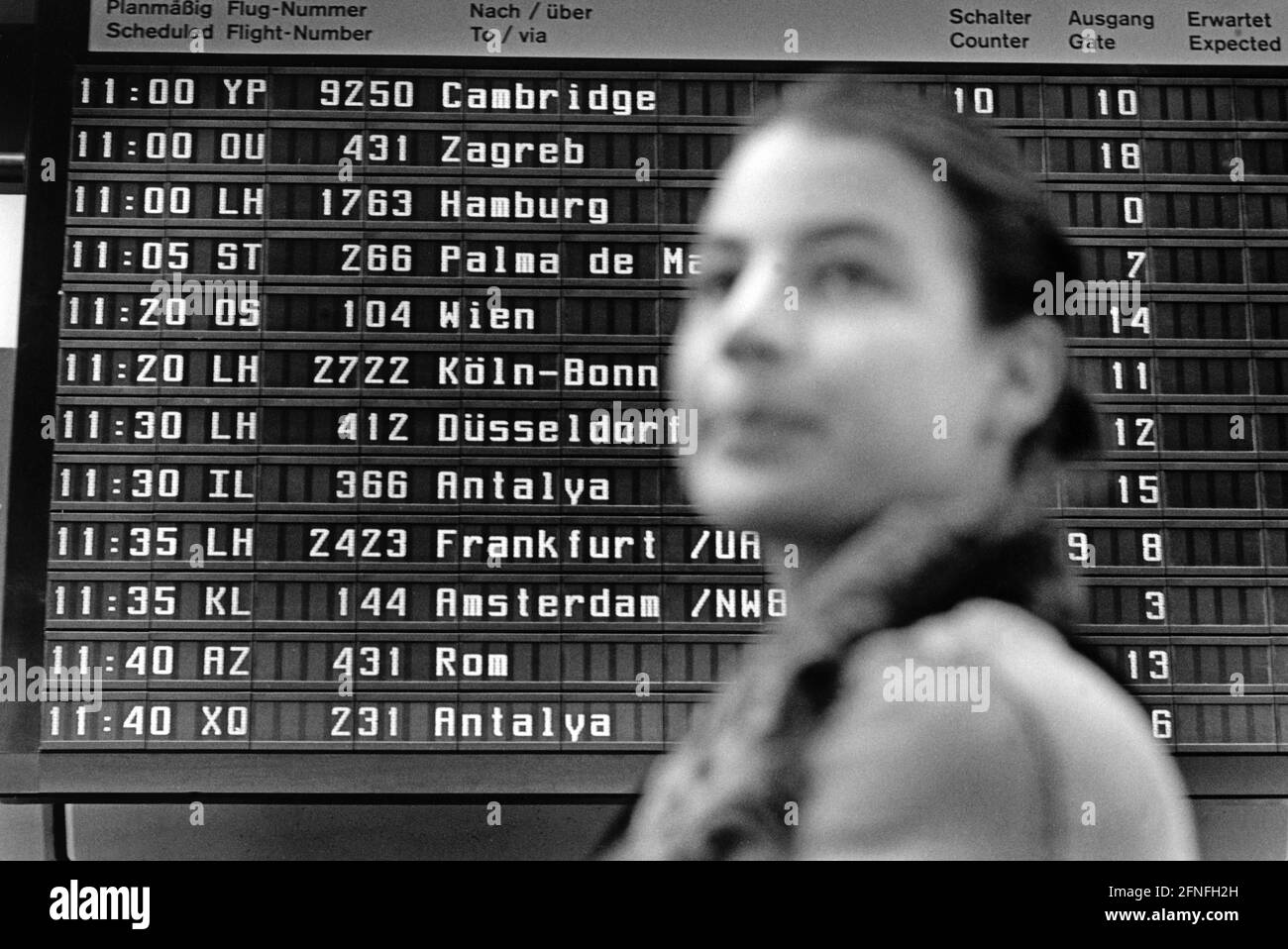 A student of the Berlin University of the Arts (HdK) in front of a departure board at Berlin-Tegel Airport. [automated translation] Stock Photo