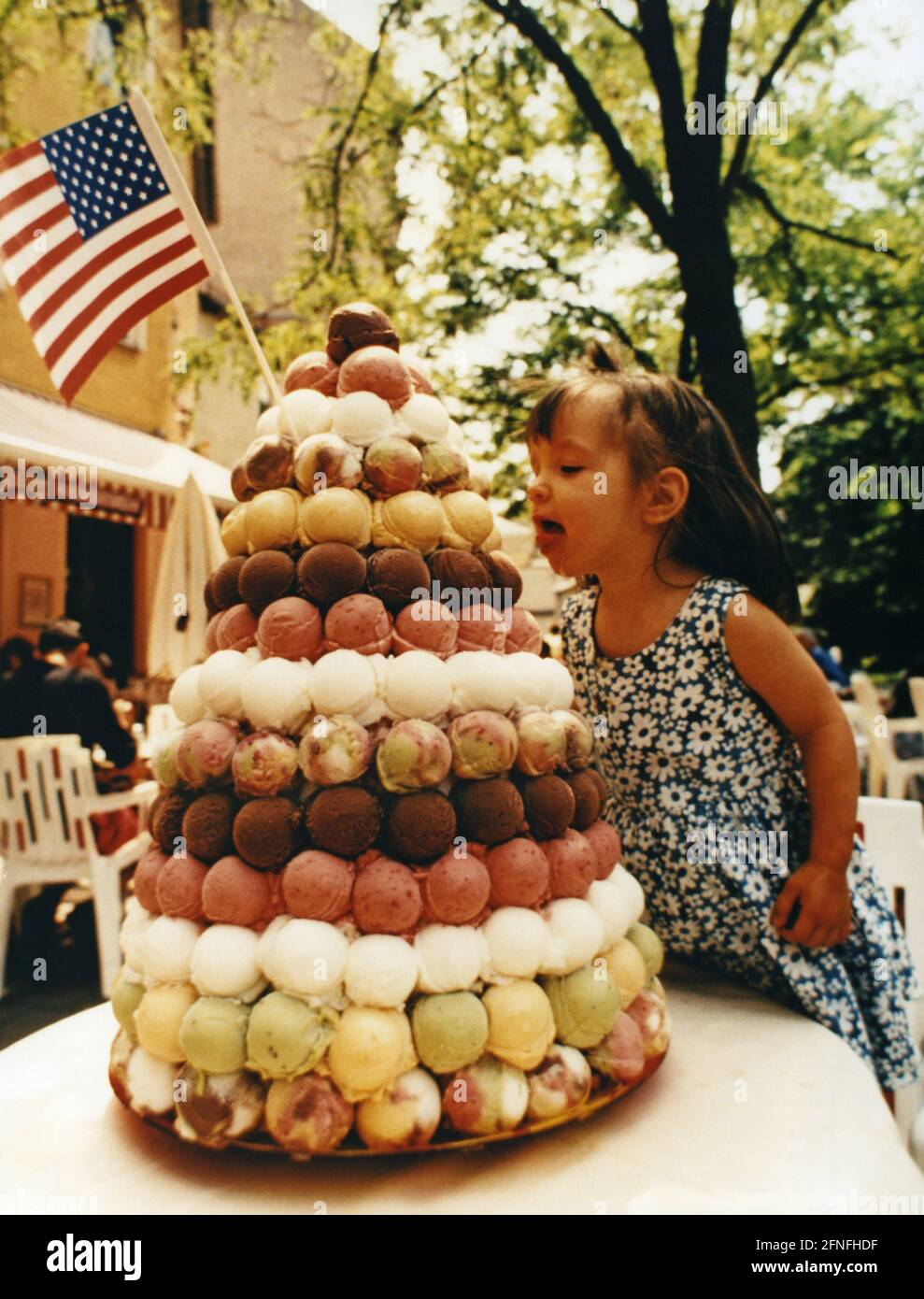 Tania tries to lick the big pyramid of ice cream. The pyramid consists