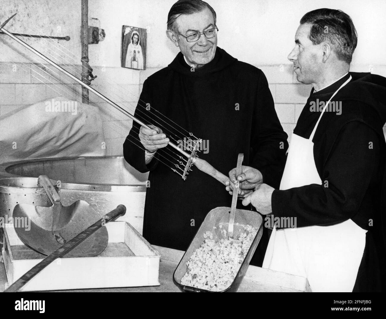 In the monastery of Wessobrunn, which became famous through the Wessobrunn prayer, the cheese culture was continued. Together with Superior Father Gilbert (left), Frater Adalrich, as a trained cheese maker, checks a typical Lenten food, Kässpatz'n. Gilbert holds the cheese harve with which the curds were cut in the cheese dairy. [automated translation] Stock Photo