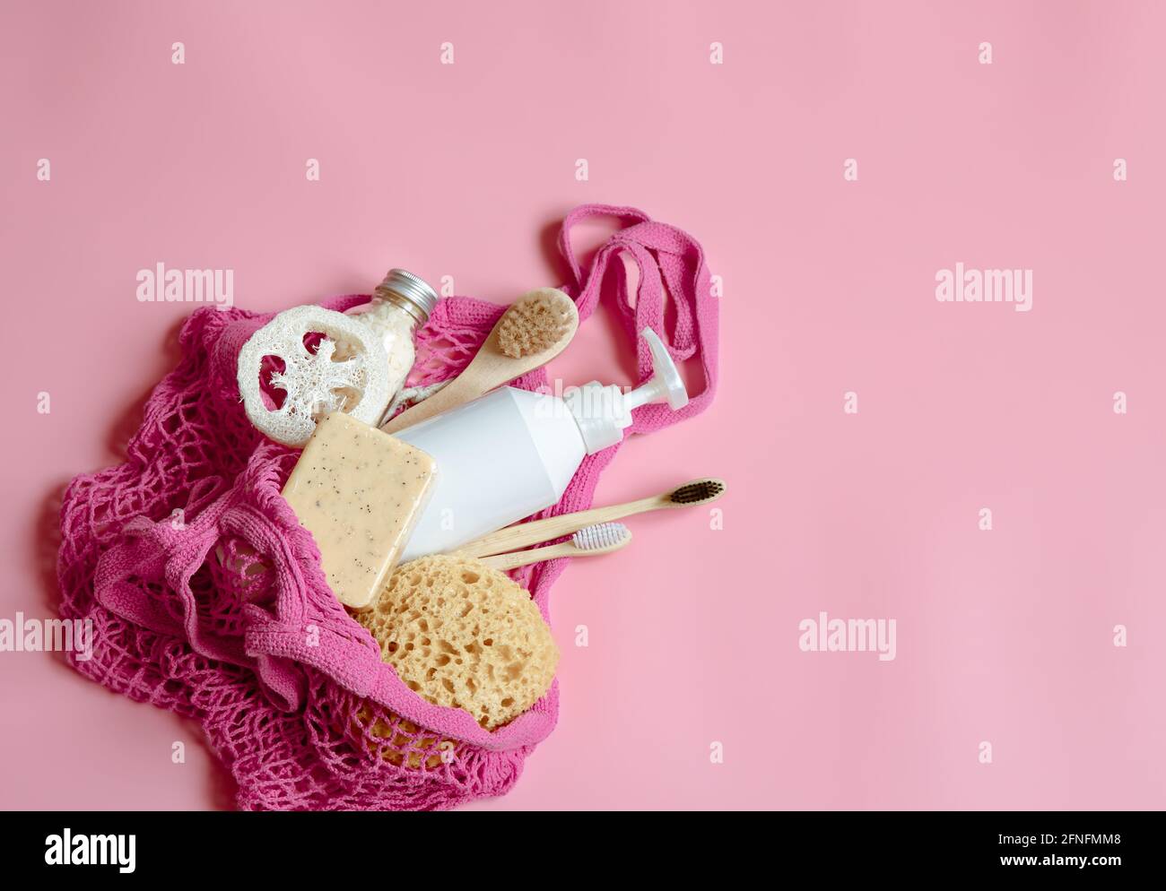 Flat lay spa composition with personal hygiene items and bath accessories in a string bag. Stock Photo