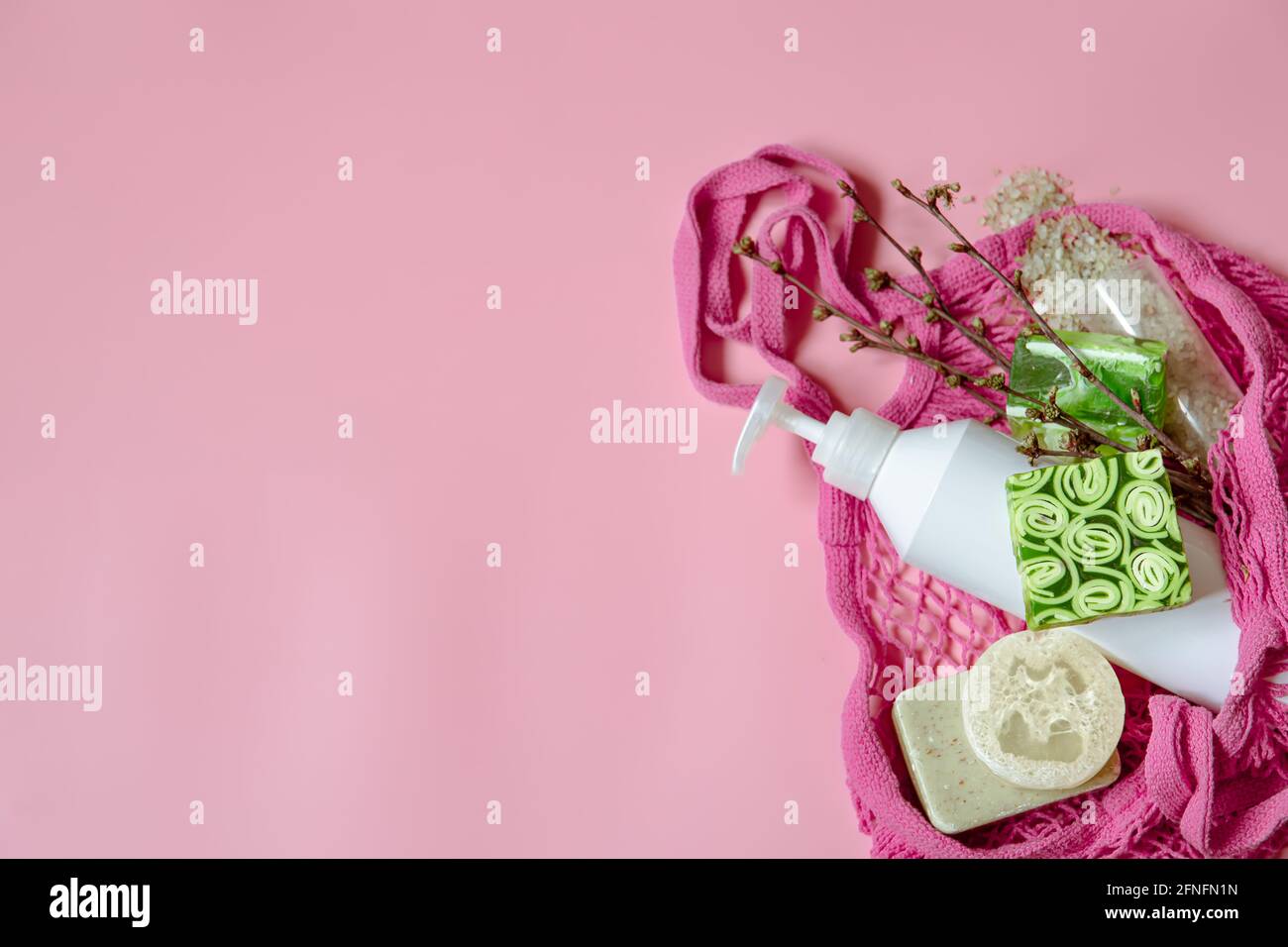 Flat lay spa composition with personal hygiene items and bath accessories in a string bag. Stock Photo