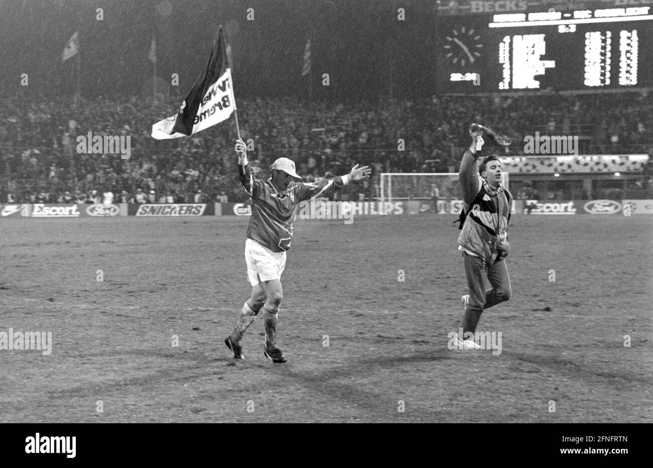 FOOTBALL 1. BUNDESLIGA SEASON 1993/1994 Quarterfinal SV Werder Bremen - RSC Anderlecht 08.12.1993 Ulrich Borowka (left, SV Werder Bremen) cheers with flag and fan after the final whistle. The scoreboard shows the historic result of 5:3. PHOTO: WEREK Press Photo Agency xxNOxMODELxRELEASExx [automated translation] Stock Photo