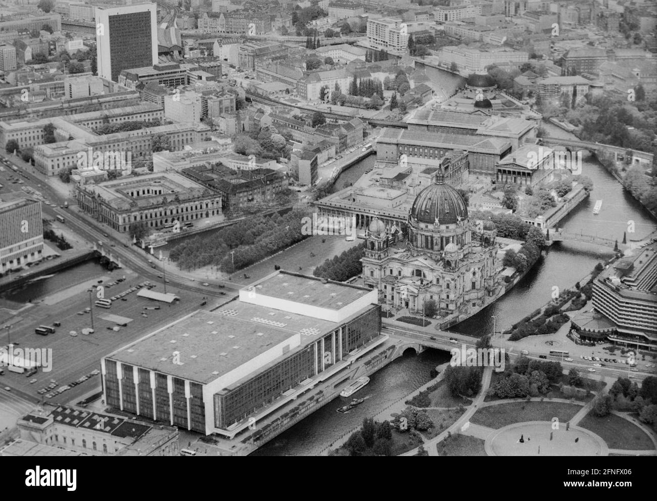Berlin-City / GDR / 5 / 1991 The Palace of the Republic at the Schlossplatz, on the right Museum Island, on the left Unter den Linden, in front the river Spree // Mitte / Stadtschloss // Parliament /Unter den Linden / History In place of the City Palace, which was demolished in 1950, the Palace of the Republic was built from 1973 on, 180 m long, 32 m wide. In it were various facilities. In the large hall events took place, it held 5000 visitors. In the small hall the GDR chamber of people met. There were also restaurants and cafes for 1500 guests. From 2016 the new building is called Stock Photo