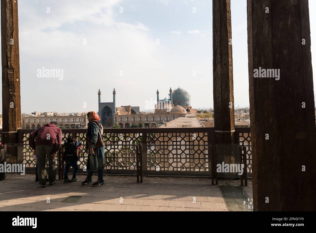 Small family on the terrace of Ali Qapu Palace overlooking the Naqsh-e Jahan Square and Shah Mosque. Isfahan, Iran. Stock Photo