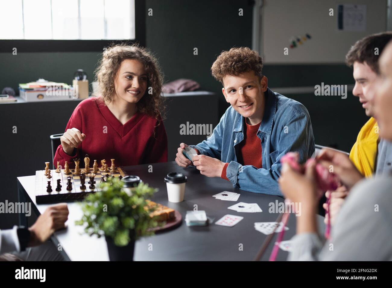 Group of people playing cards and board games in community center