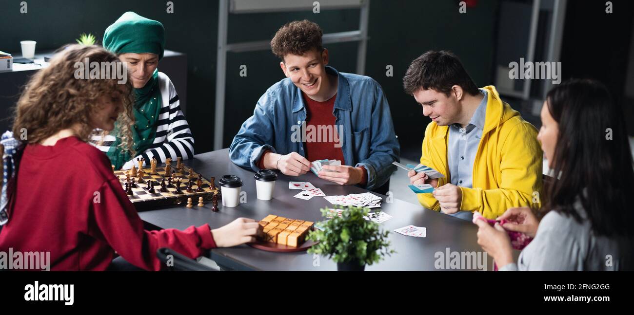 Group of people playing cards and board games in community center