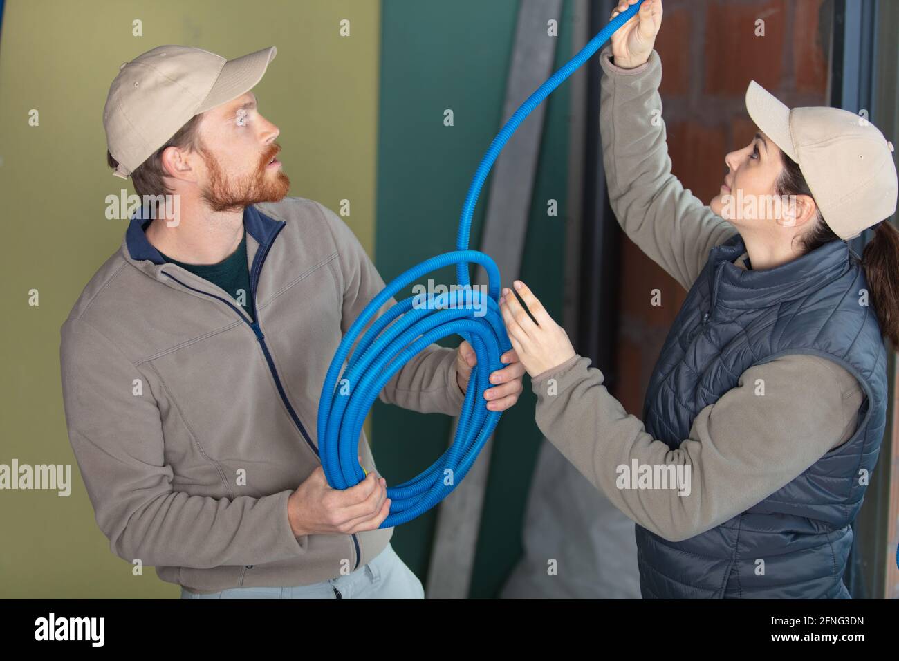 male and female electricians taking measurements Stock Photo