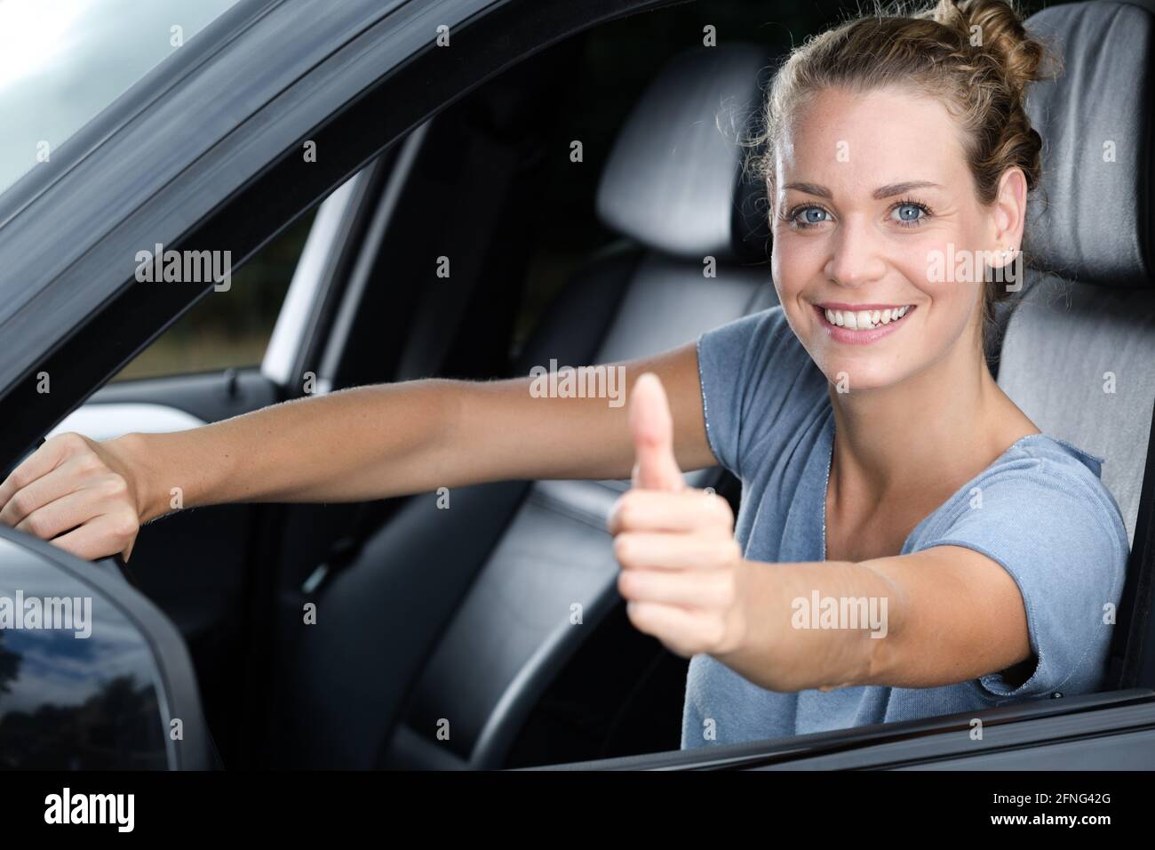 happy car owner looking at camera showing thumbs up Stock Photo Alamy