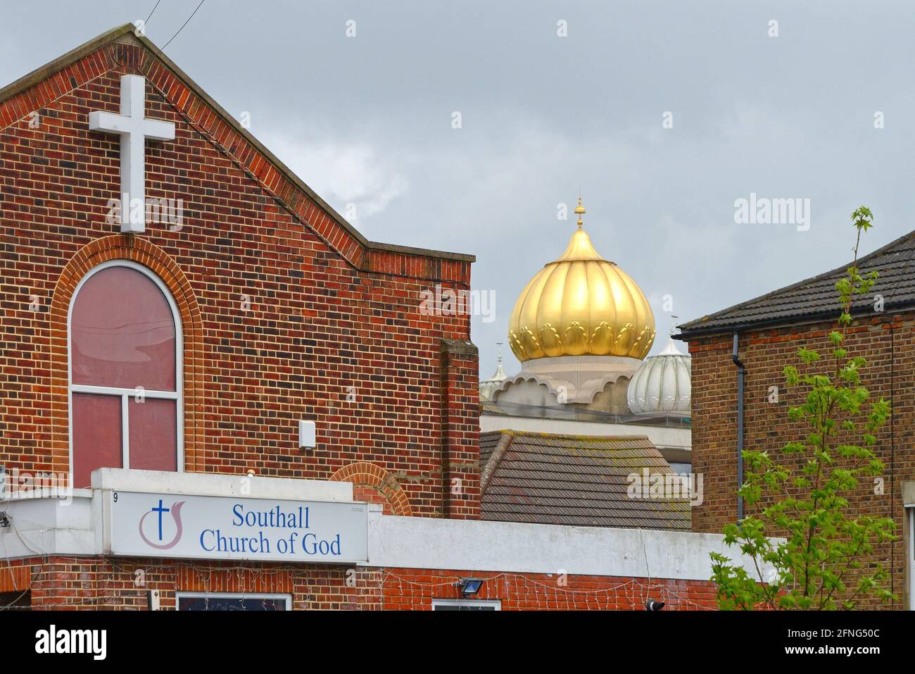 The golden dome of the Siri Guru Singh Sabha Gurdwara temple dominating the skyline in Southall London borough of Ealing England UK Stock Photo