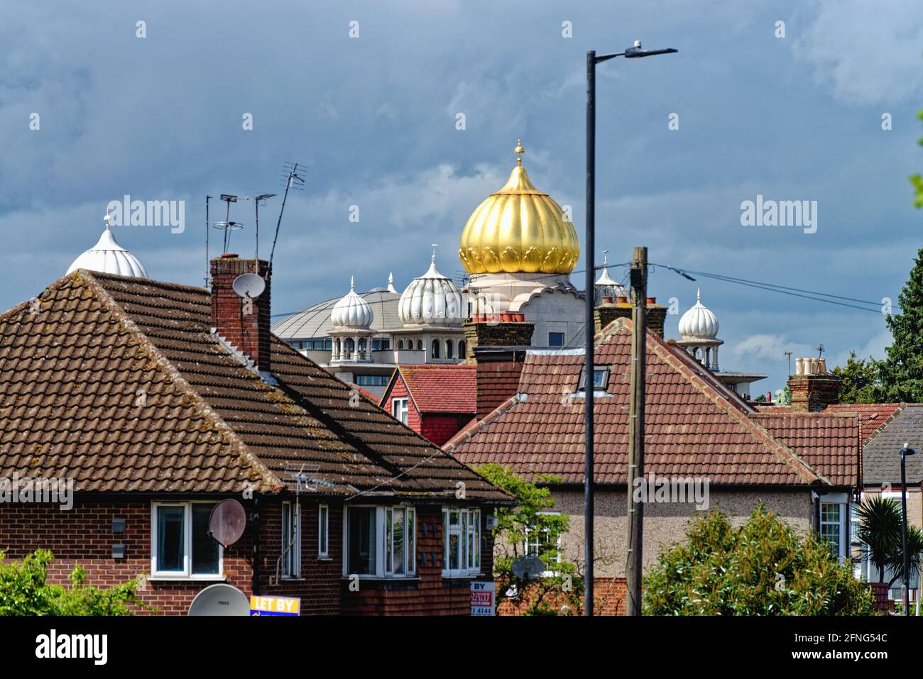 The golden dome of the Siri Guru Singh Sabha Gurdwara temple dominating the skyline in Southall London borough of Ealing England UK Stock Photo