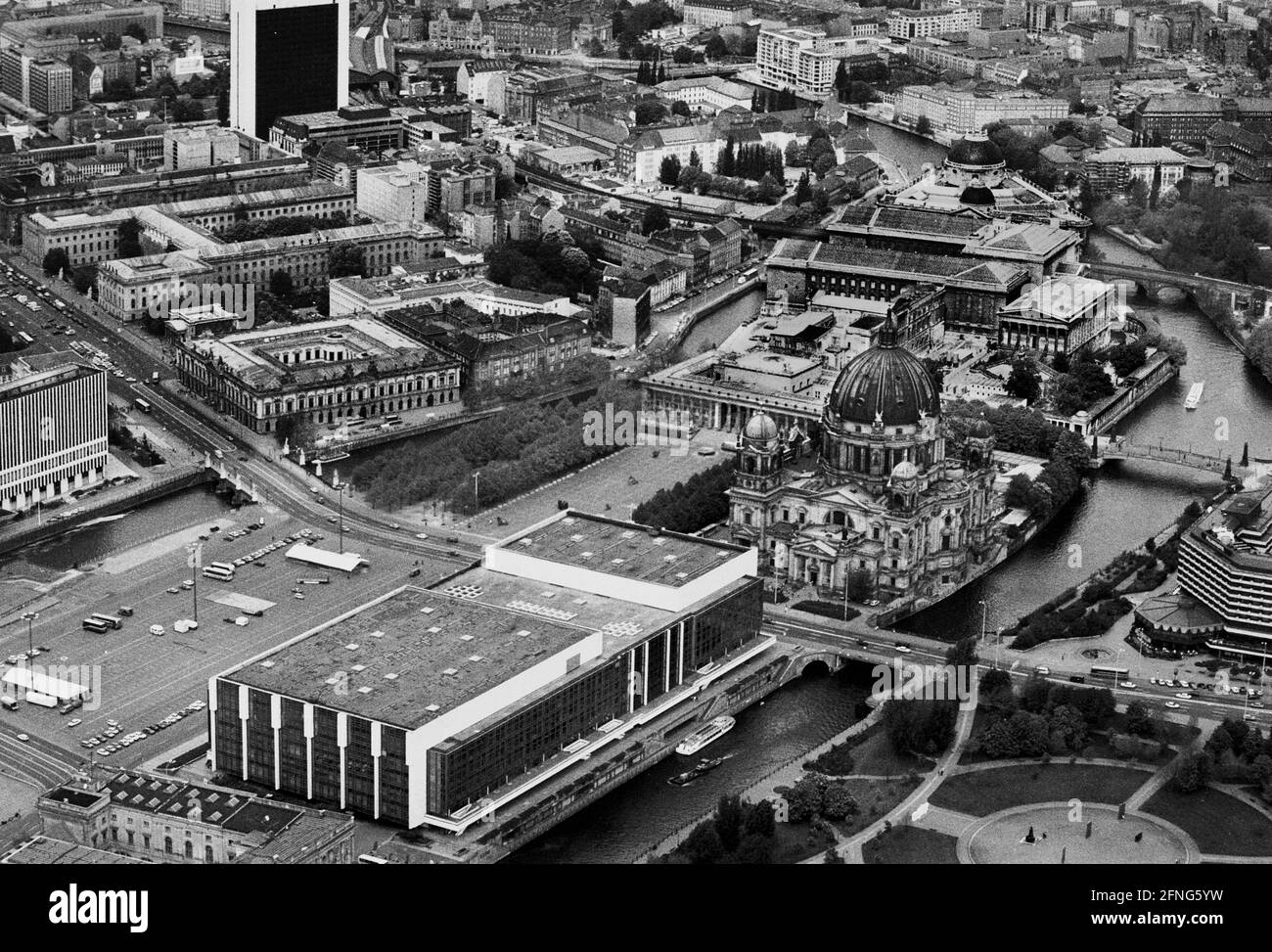 Berlin-City / GDR / 5 / 1991 The Palace of the Republic at the Schlossplatz, on the right Museum Island, on the left Unter den Linden, in front the river Spree // Mitte / Stadtschloss // Parliament /Unter den Linden / History In place of the City Palace, which was demolished in 1950, the Palace of the Republic was built from 1973 on, 180 m long, 32 m wide. In it were various facilities. In the large hall events took place, it held 5000 visitors. In the small hall the GDR chamber of people met. There were also restaurants and cafes for 1500 guests. From 2016 the new building is called Stock Photo