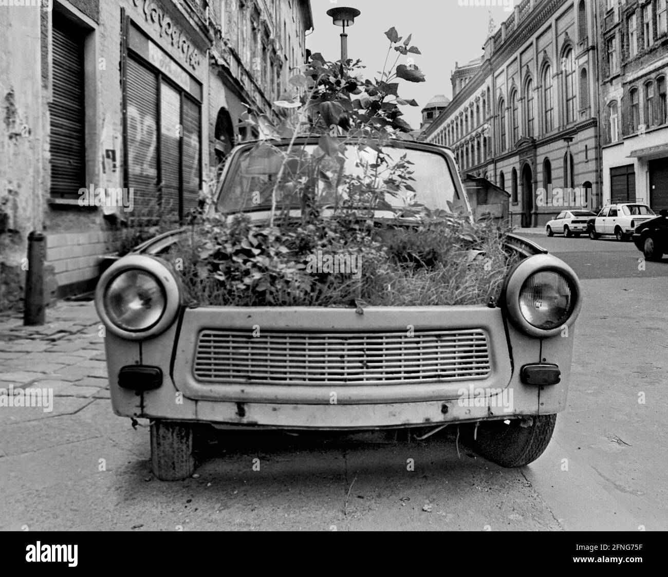 Berlin-Bezirke / DDR / 8 / 1991. The symbol of the GDR prosperity, the Trabi, as a flower box, Tucholskystrasse, Berlin-Mitte, symbol for the end of the GDR // Economy / Flowers / DDr-End *** Local Caption *** This car was called Trabi, symbol for east german wealth. Now it is a flower box and a Symbol for the end of german communism. [automated translation] Stock Photo
