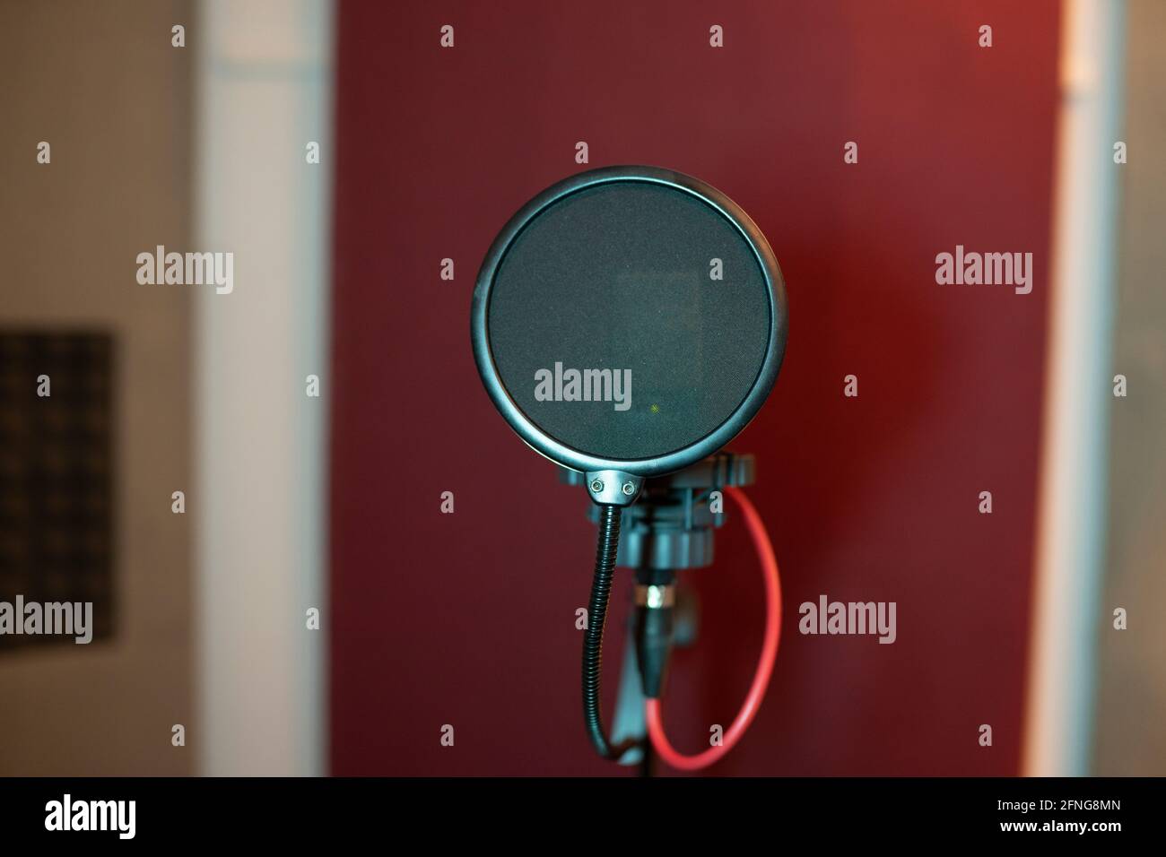 Pop filter and modern dynamic mic with wires in empty sound studio on
