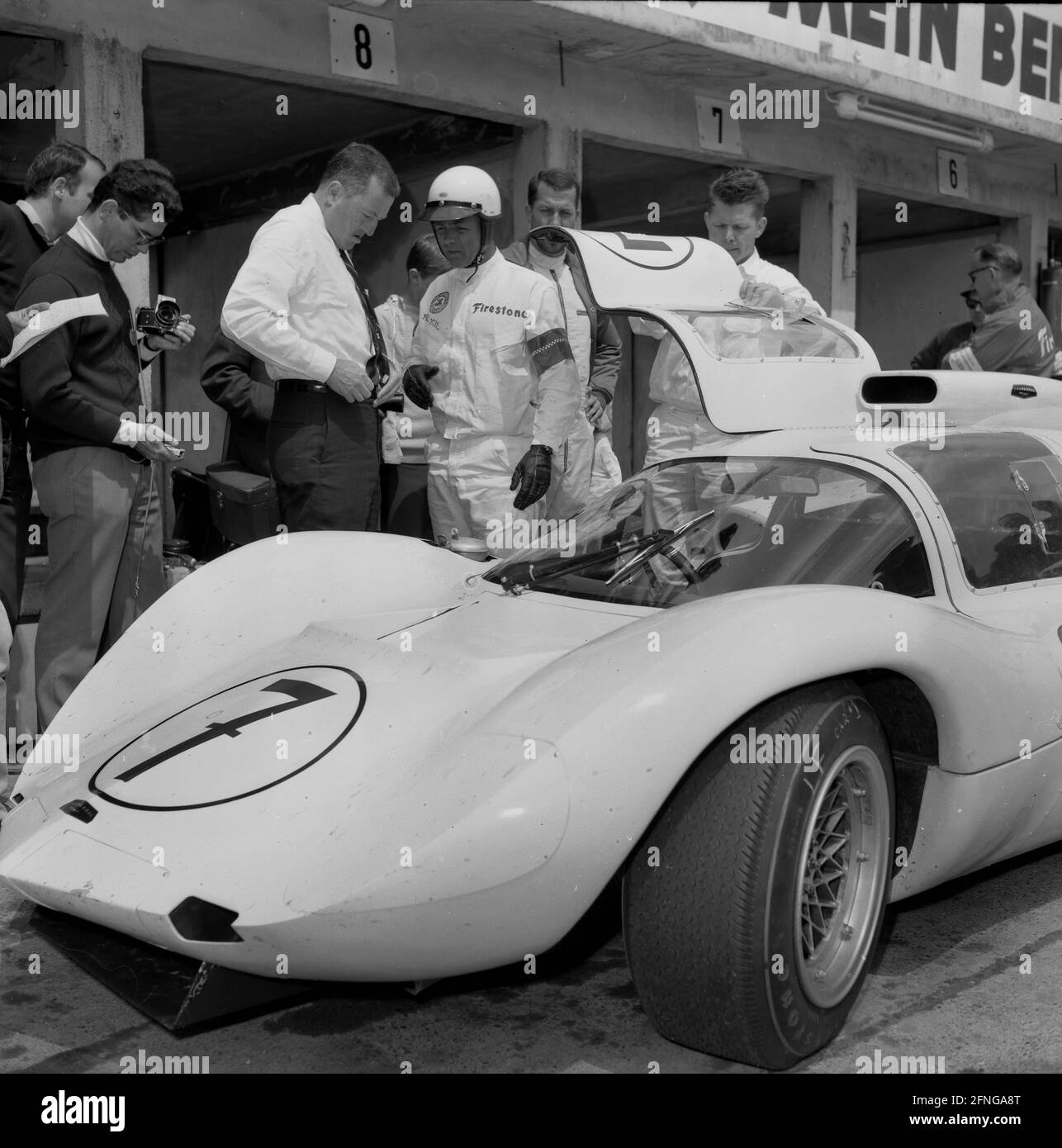1000km race on the Nürburgring 05.06.1966. Phil Hill stands at his Chaparral 2D in front of the pits. [automated translation] Stock Photo