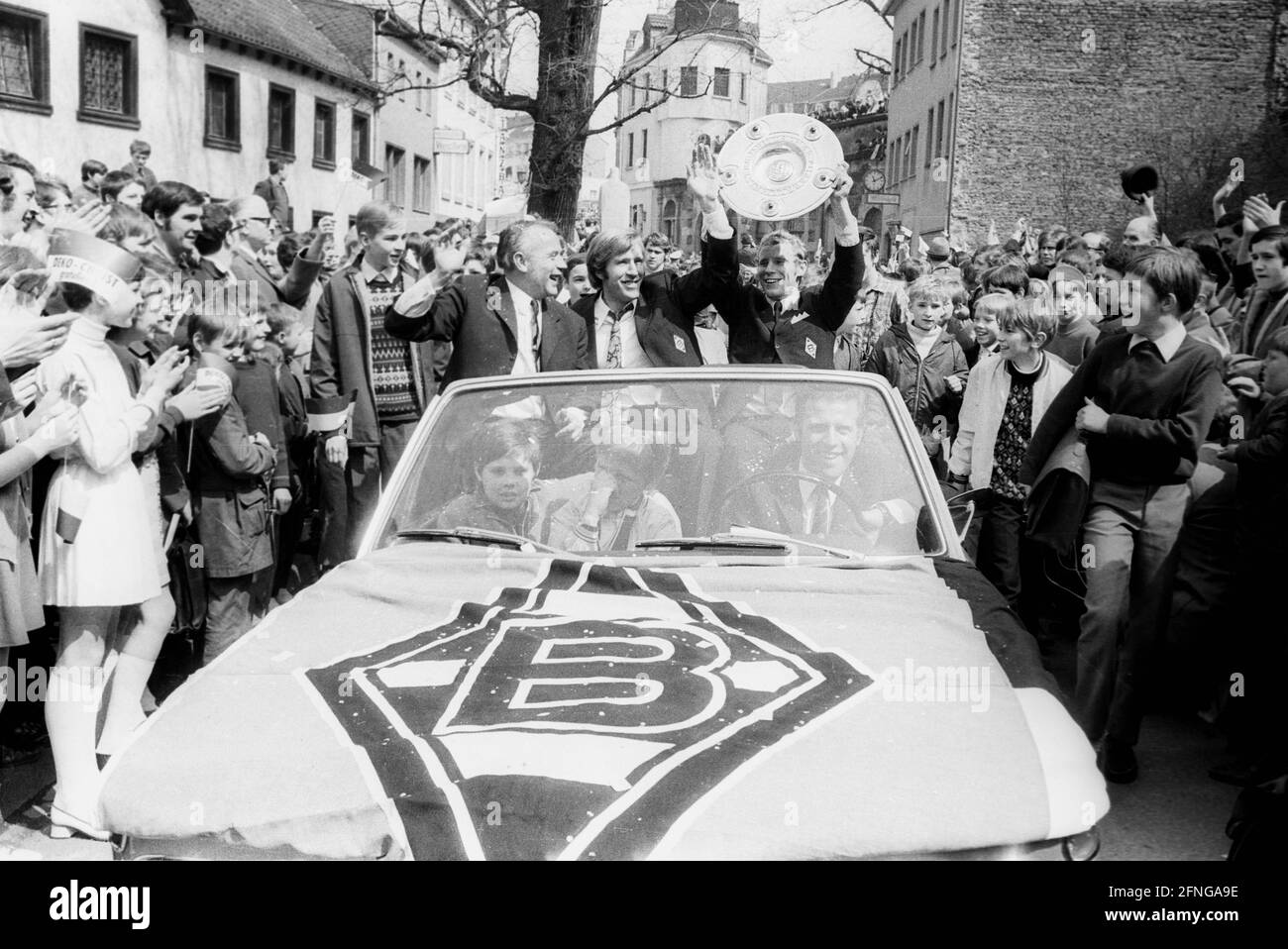 VFL Borussia Mönchengladbach German Football Champion 1969/70 during the drive through the city in the front of the car from the left coach Hennes Weisweiler, Günter Netzer and Berti Vogts with championship trophy.the motorcade is accompanied by many fans [automated translation] Stock Photo