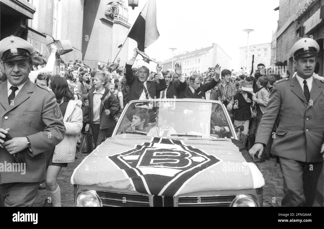 VFL Borussia Mönchengladbach German Football Champion 1969/70 during the drive through the city in the front of the car from the left coach Hennes Weisweiler with championship trophy, Günter Netzer and Berti Vogts, the motorcade is accompanied by 2 policemen and many fans. [automated translation] Stock Photo