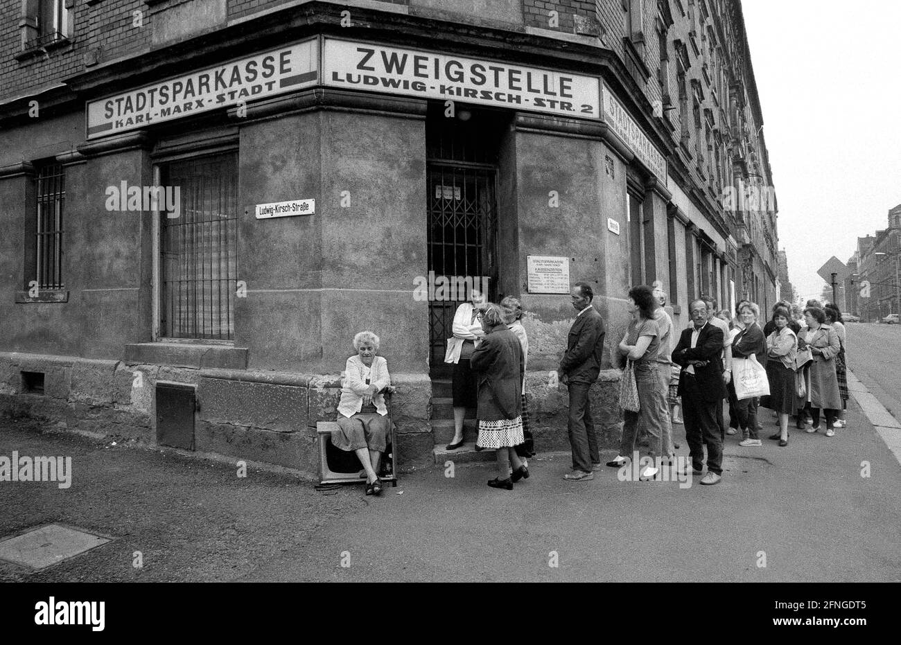 Saxony / GDR country / Early 1990 Karl-Marx-Stadt, Chemnitz Waiting in front of the city savings bank to hand in the application for money exchange. Every GDR citizen had to open an account if he wanted to have D-Mark in the middle of the year. // Unification / Banks / *** Local Caption *** East Germany / Unification / Communism / Queuing for West Mark in Karl Marx City. An old woman is waiting on a junk TV device. Every East German had to open an account to get west German money. Here people are registering. The city was renamed to Chemnitz again in 1990. [automated translation] Stock Photo
