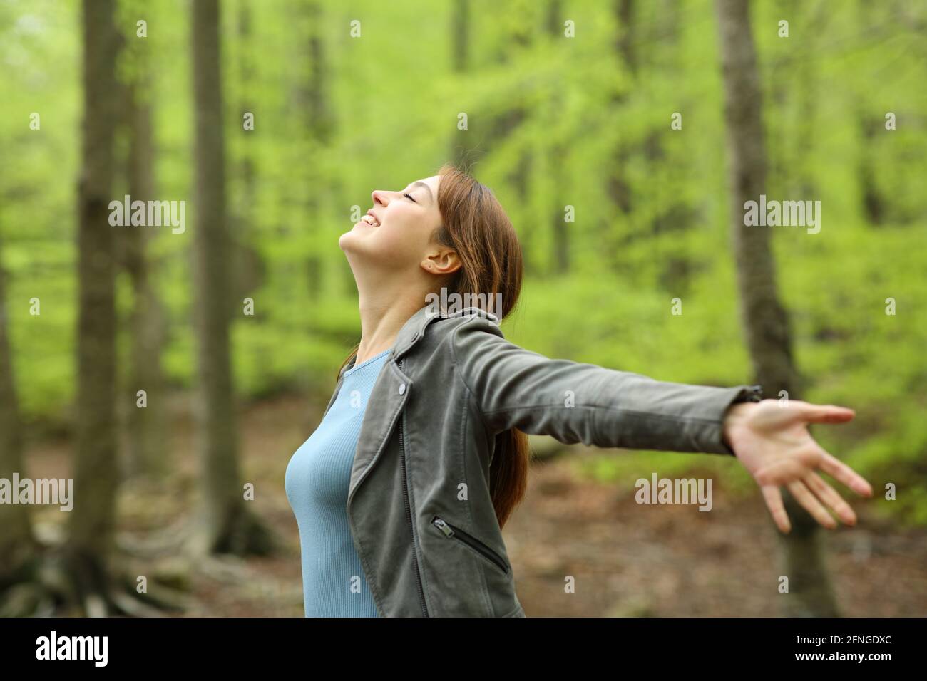 Happy woman spreading outstretching arms in a green forest Stock Photo ...