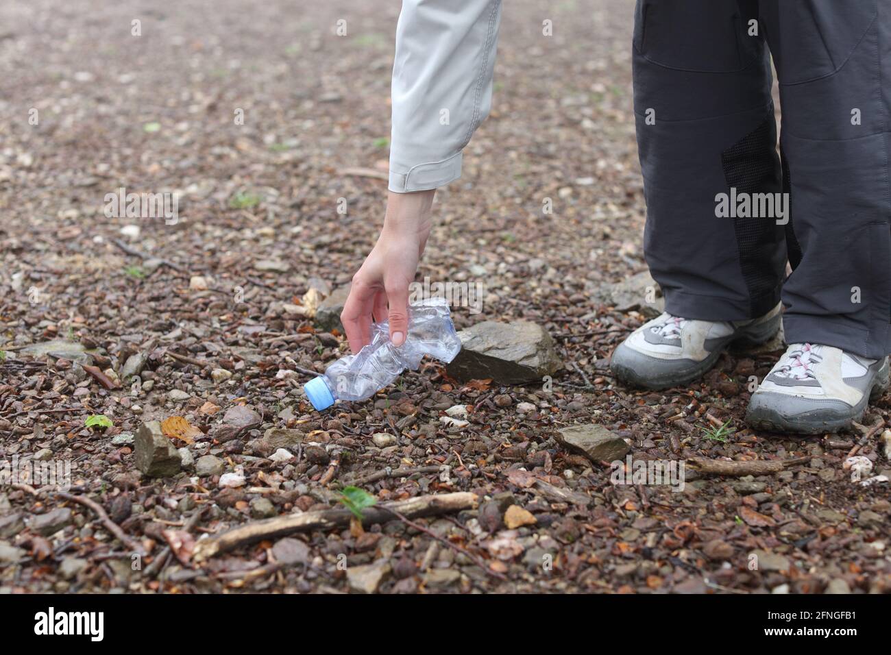 Close up of a hiker picking up trash in the mountain or park Stock Photo
