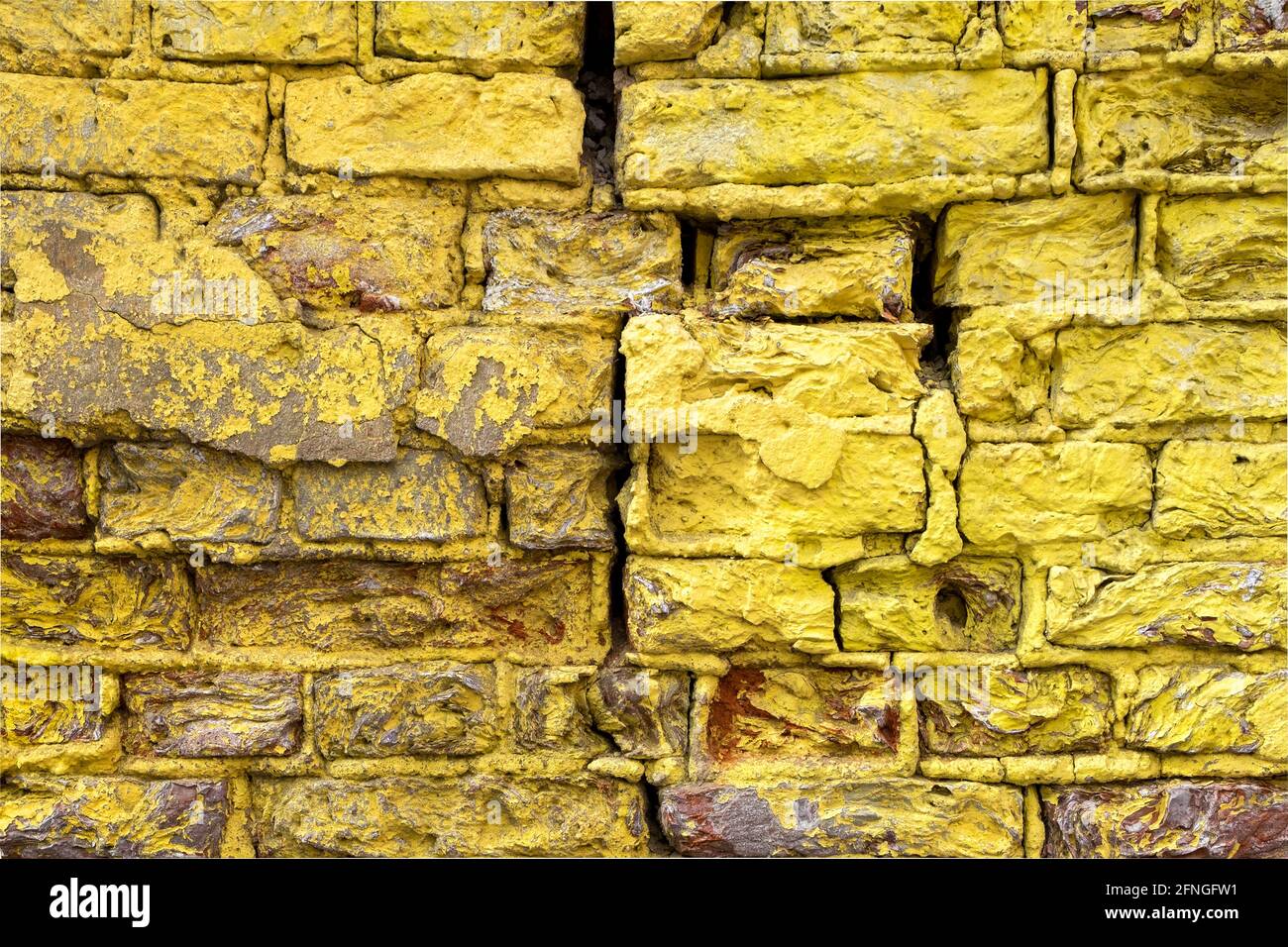 Close-up of a fragment of an old wall with bright yellow brickwork Stock Photo