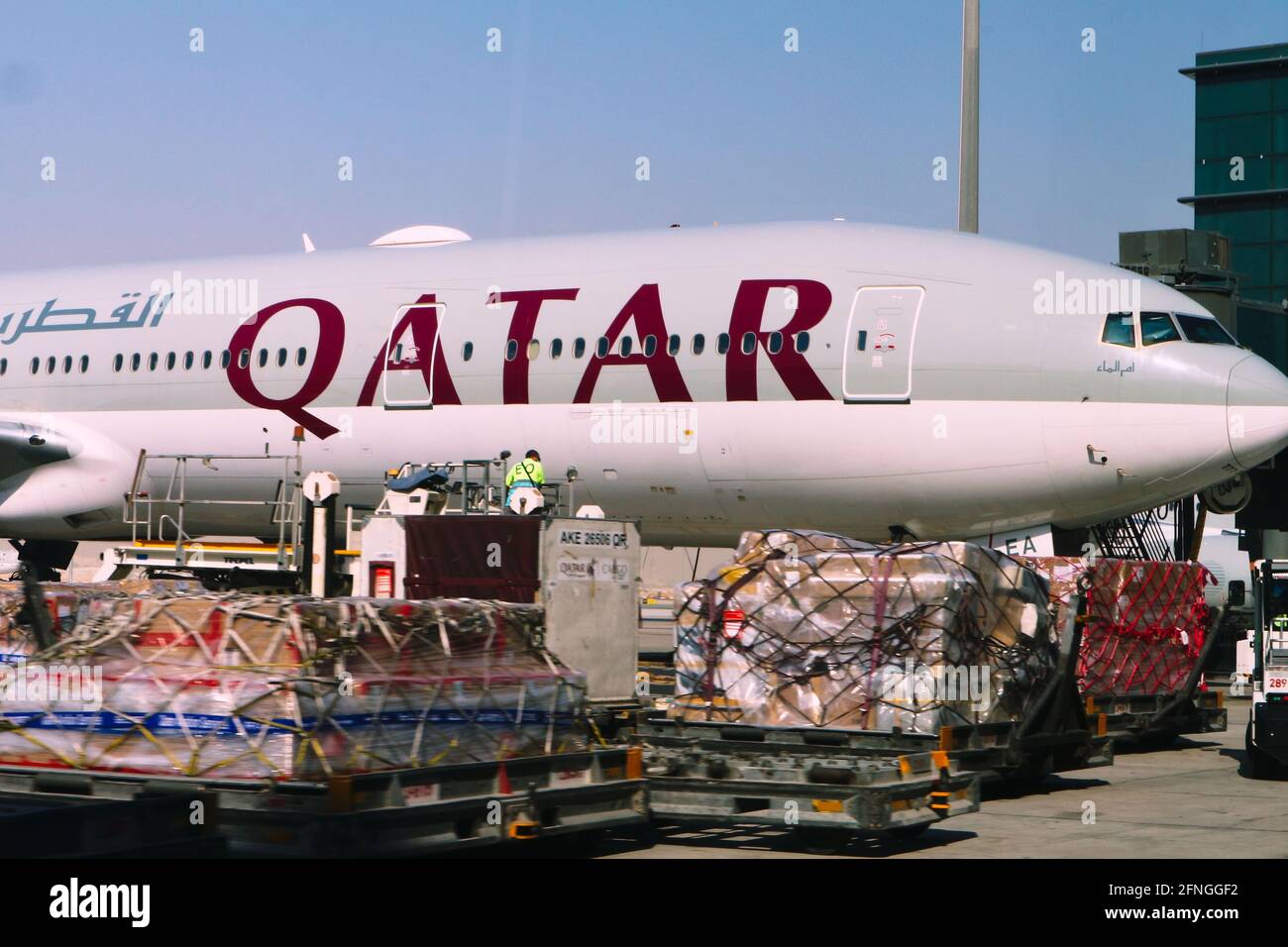 Doha, Qatar – May 12, 2021: Qatar Airways plane being loaded on the tarmac at Hamad International Airport Stock Photo