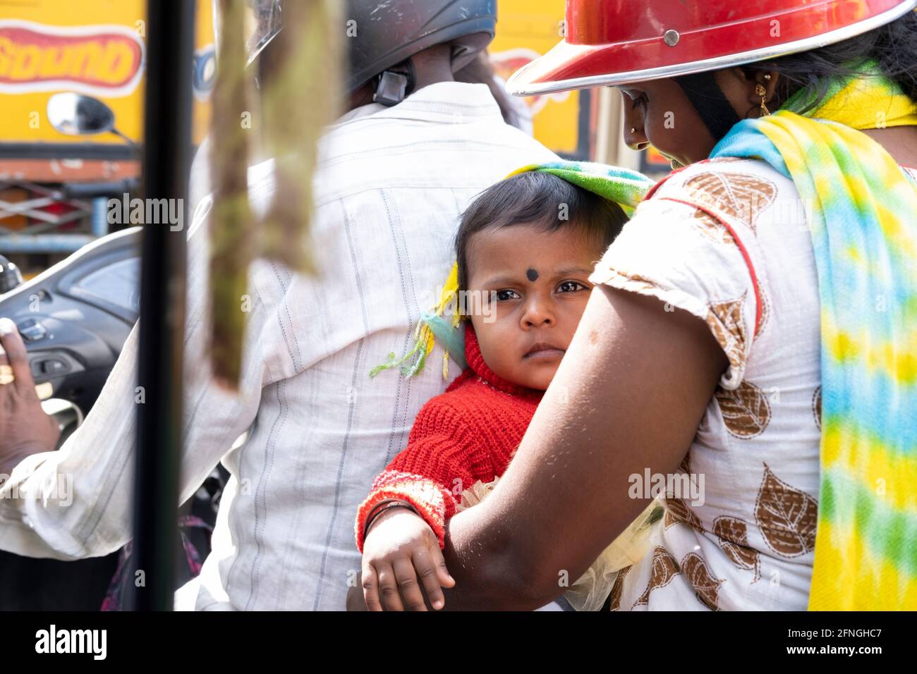 Child with his mother on a motorbike in Bangalore, Karnataka, India, July 2019 Stock Photo