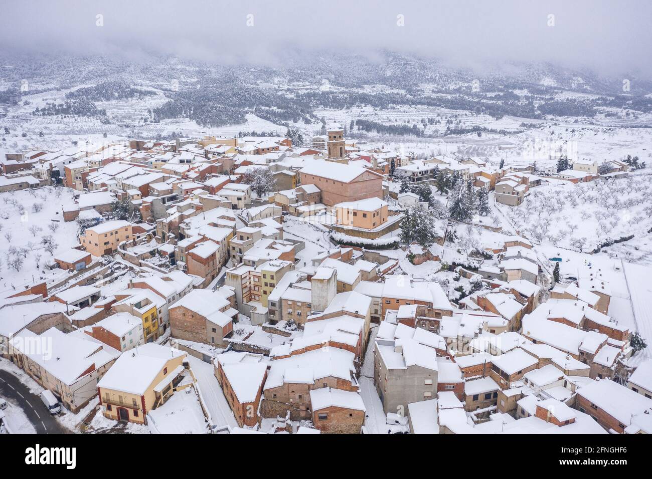 Aerial view of the village of Ulldemolins and its surroundings of olive groves and fruit trees during a snowfall (Priorat, Tarragona, Catalonia) Stock Photo
