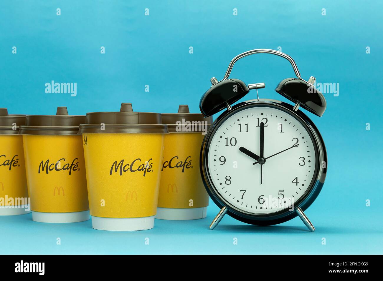 close up view of coffee maker, alarm clock and cup of coffee isolated on  red Stock Photo by LightFieldStudios