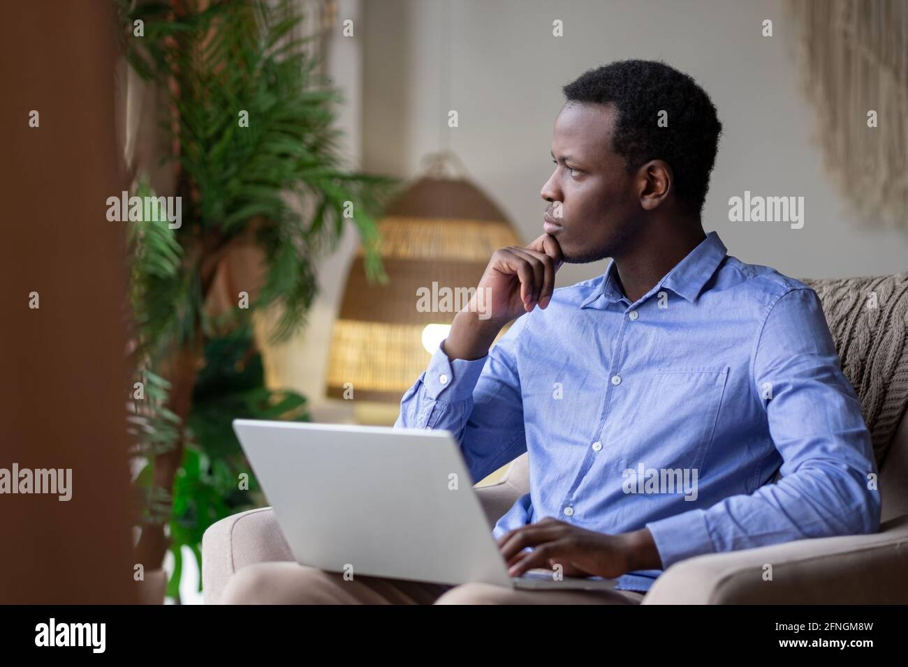 African man surfing the internet in his room at home Stock Photo