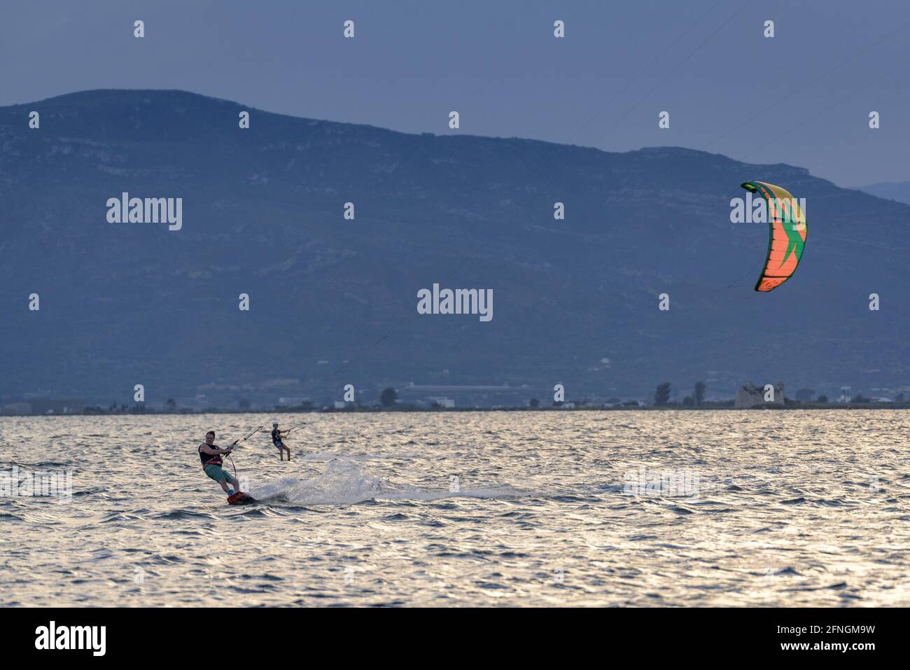 Kitesurfers at sunset in the Alfacs Bay (Ebro Delta, Tarragona, Catalonia, Spain) ESP: Practicantes de kitesurf, al atardecer, en la Badia dels Alfacs Stock Photo
