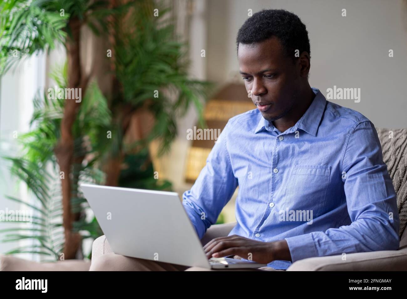 African man surfing the internet in his room at home Stock Photo