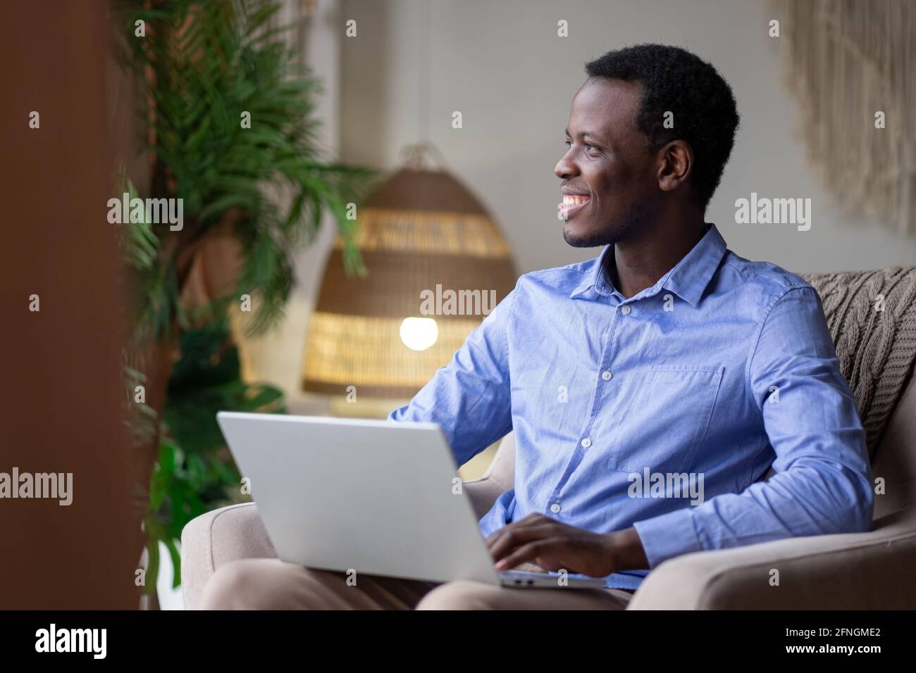 African man surfing the internet in his room at home Stock Photo