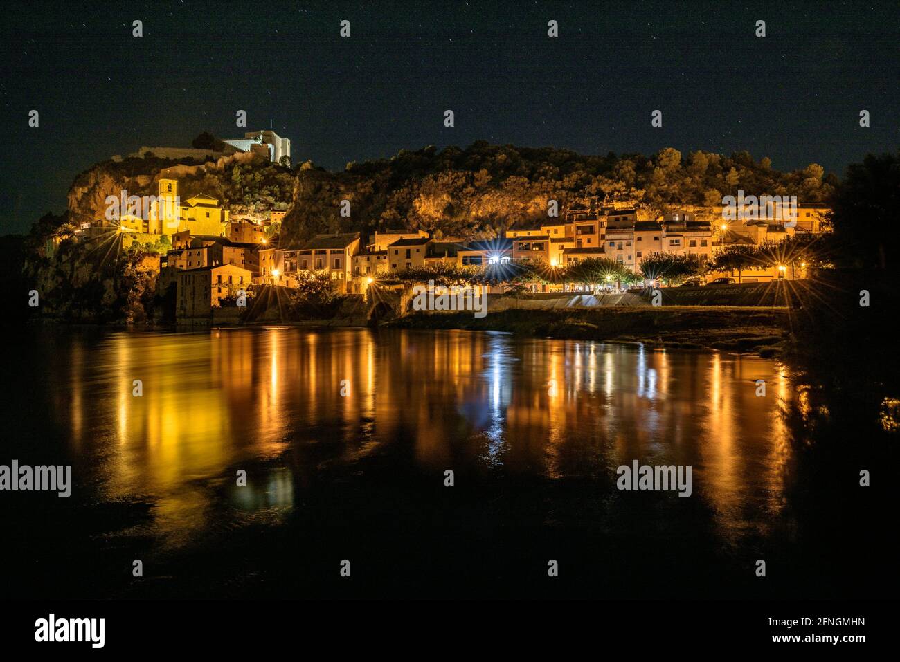 Miravet Town and Castle, at night, and reflections on the Ebro river (Ribera d'Ebre, Tarragona, Catalonia, Spain) ESP: Pueblo y Castillo de Miravet Stock Photo